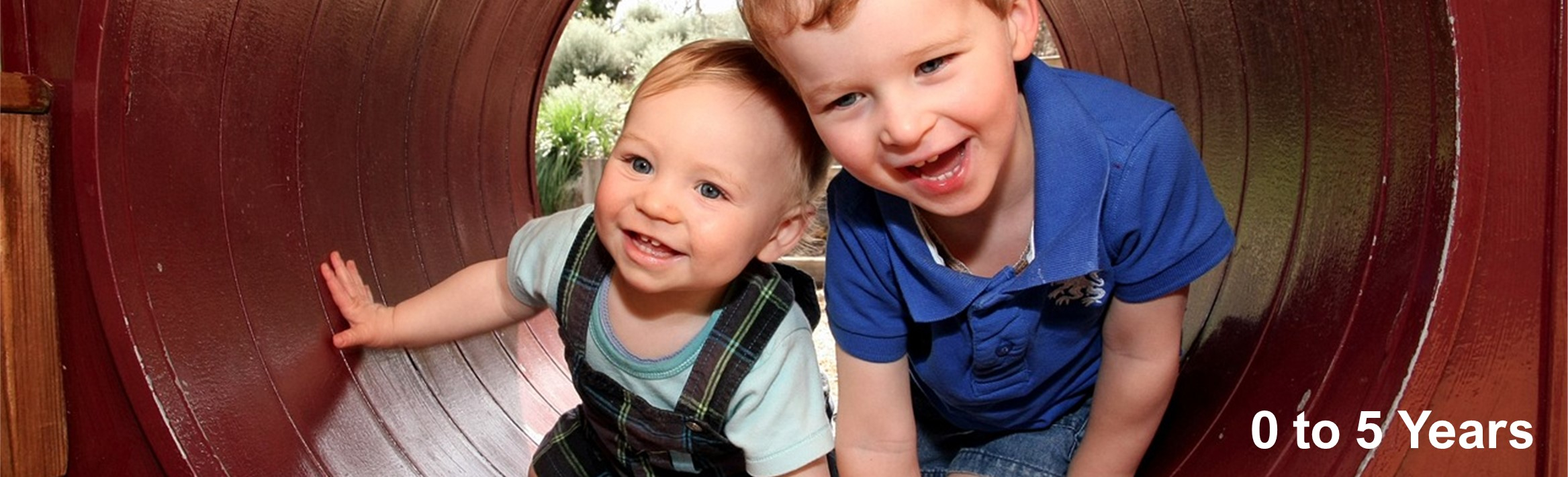 Long banner showing image of 2 small children crawling through a concrete tube.