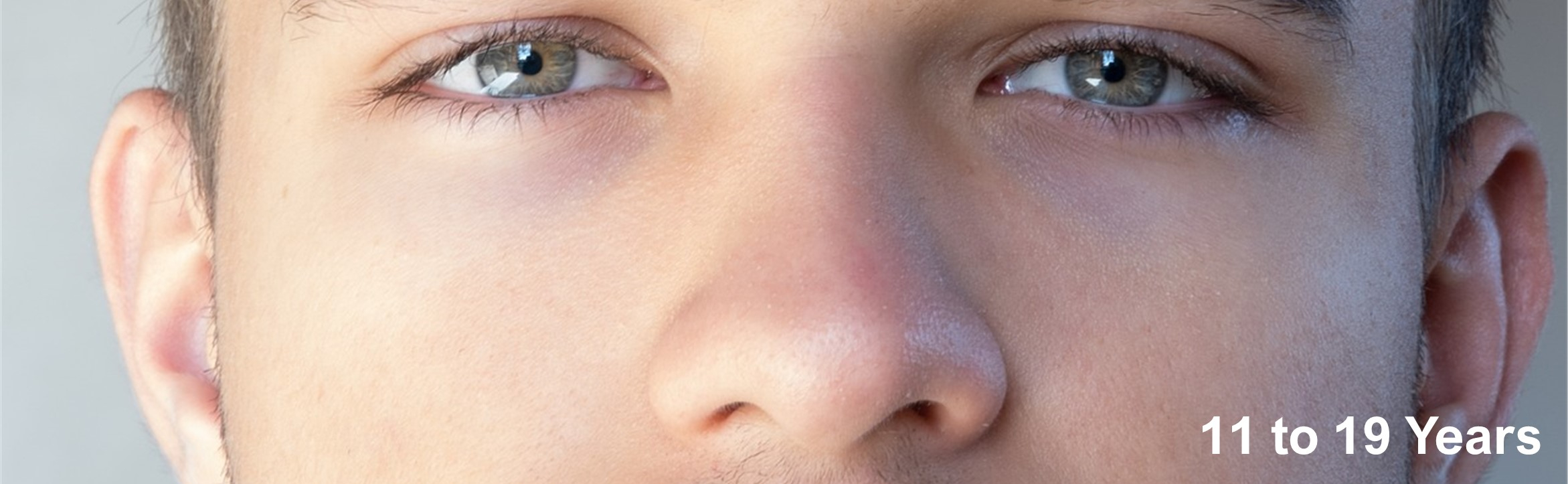 Long banner with section of a young mans face, showing his eyes and no nose